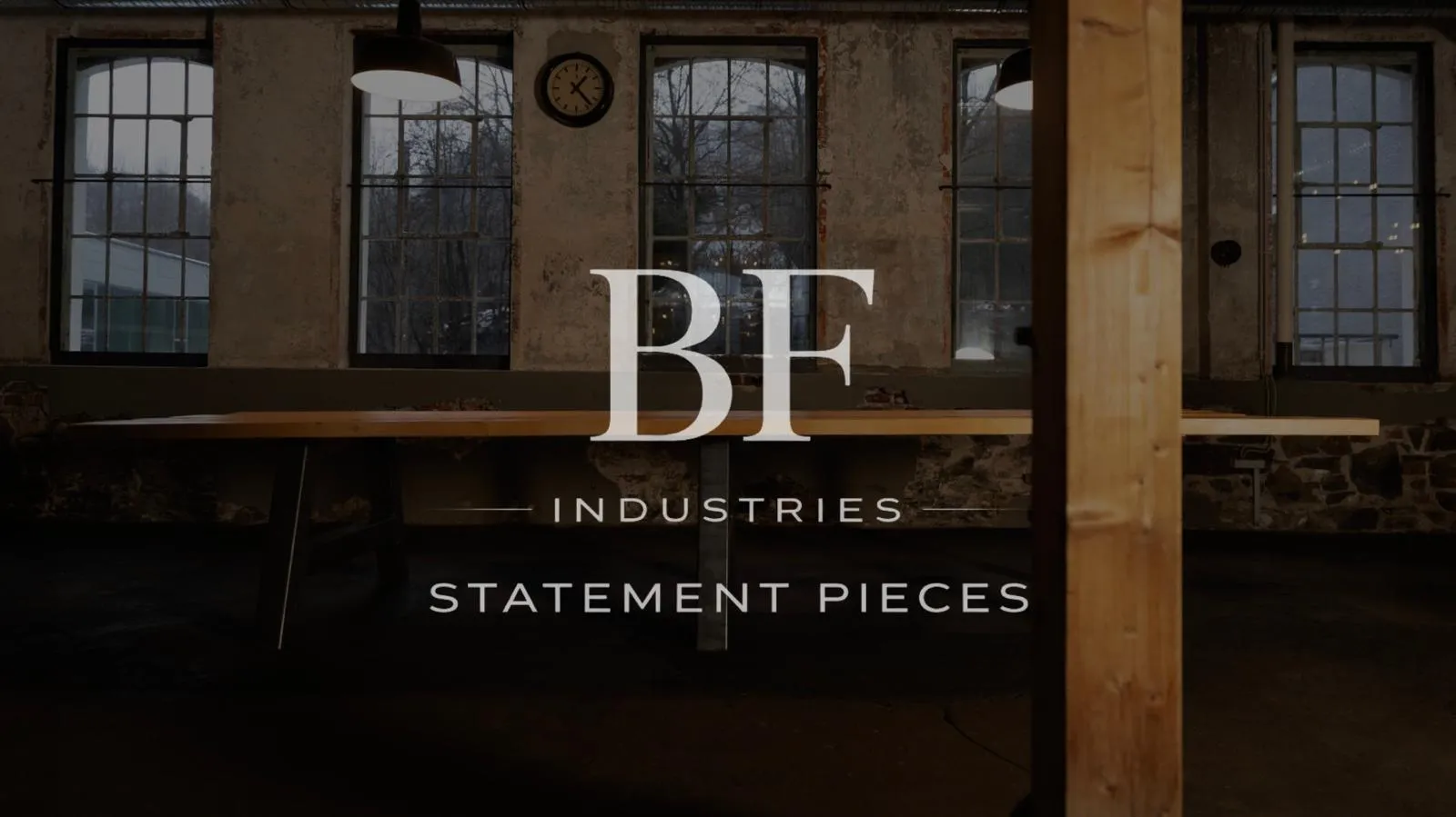 Der statement pieces als Tisch ist im gesamten vor einer alten Fabrik Fensterfront zu sehen und im Vordergrund ein senkrechter Balken.